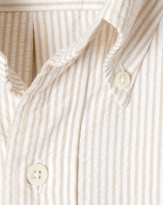 Close-up of a beige and white striped shirt with buttons.