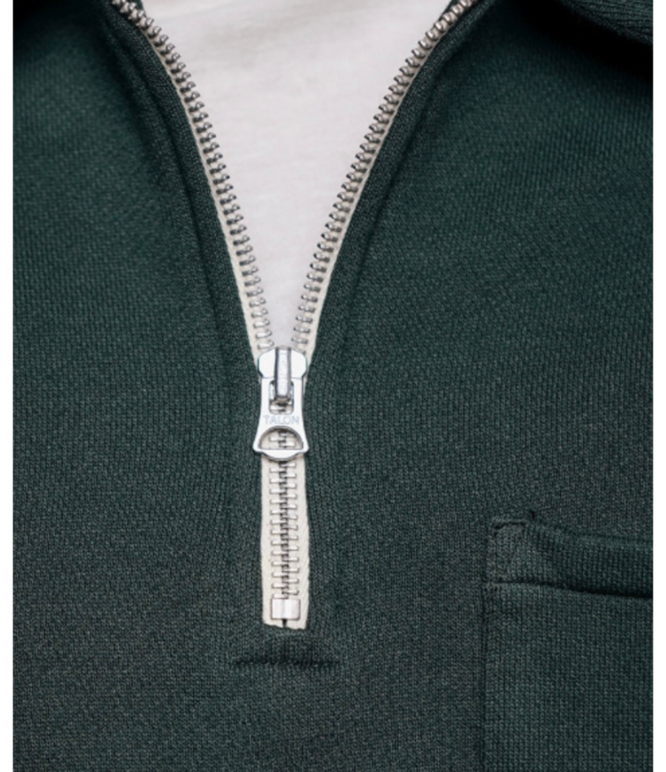 Close-up of a green hoodie with a silver zipper