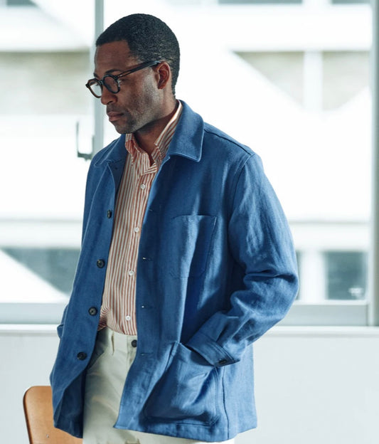 Man wearing a blue jacket and glasses indoors