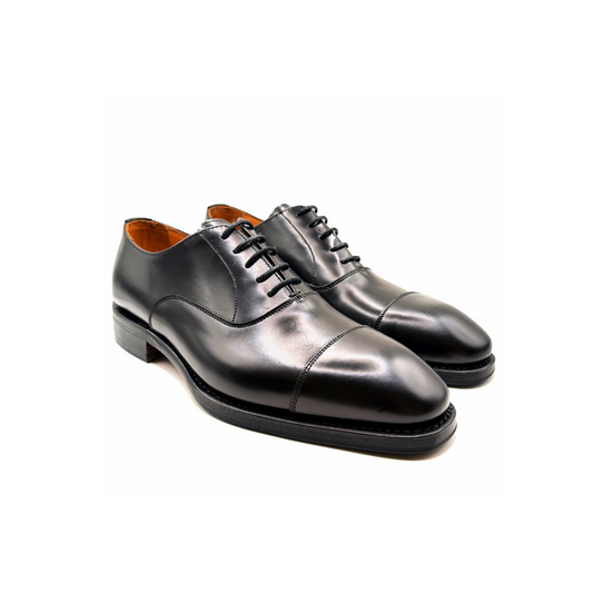Pair of black leather dress shoes on a white background