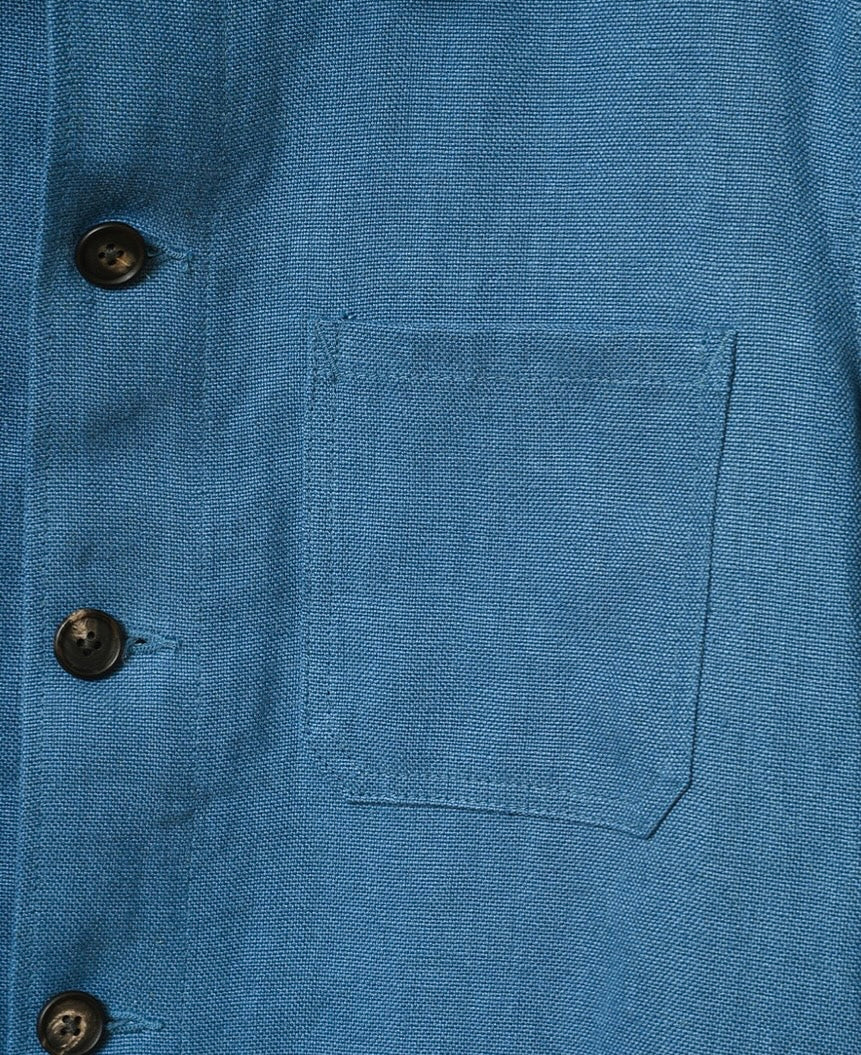 Close-up of a blue shirt with buttons and a pocket
