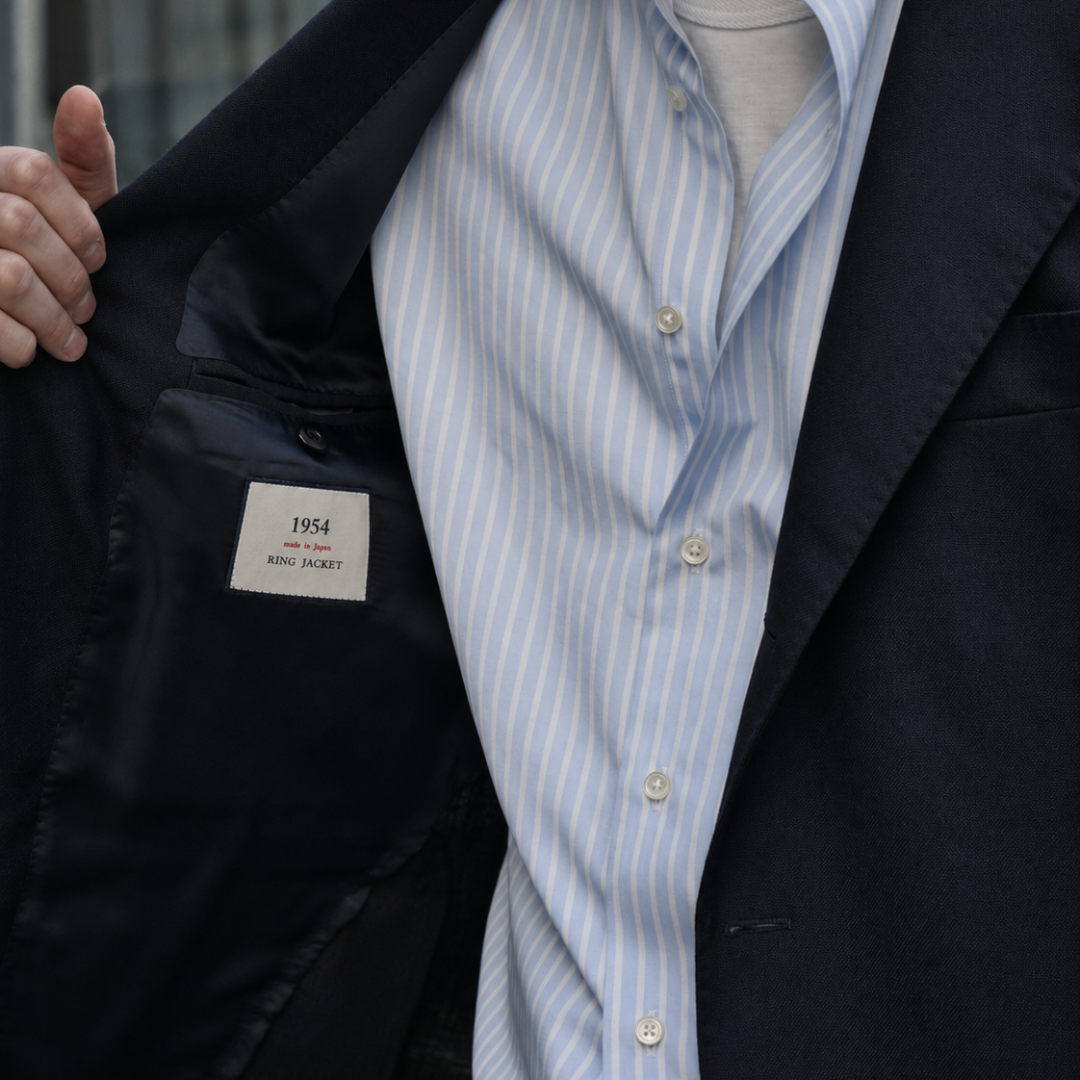 Ring Jacket navy double-breasted blazer with structured lapels and tailored fit, displayed on a hanger.