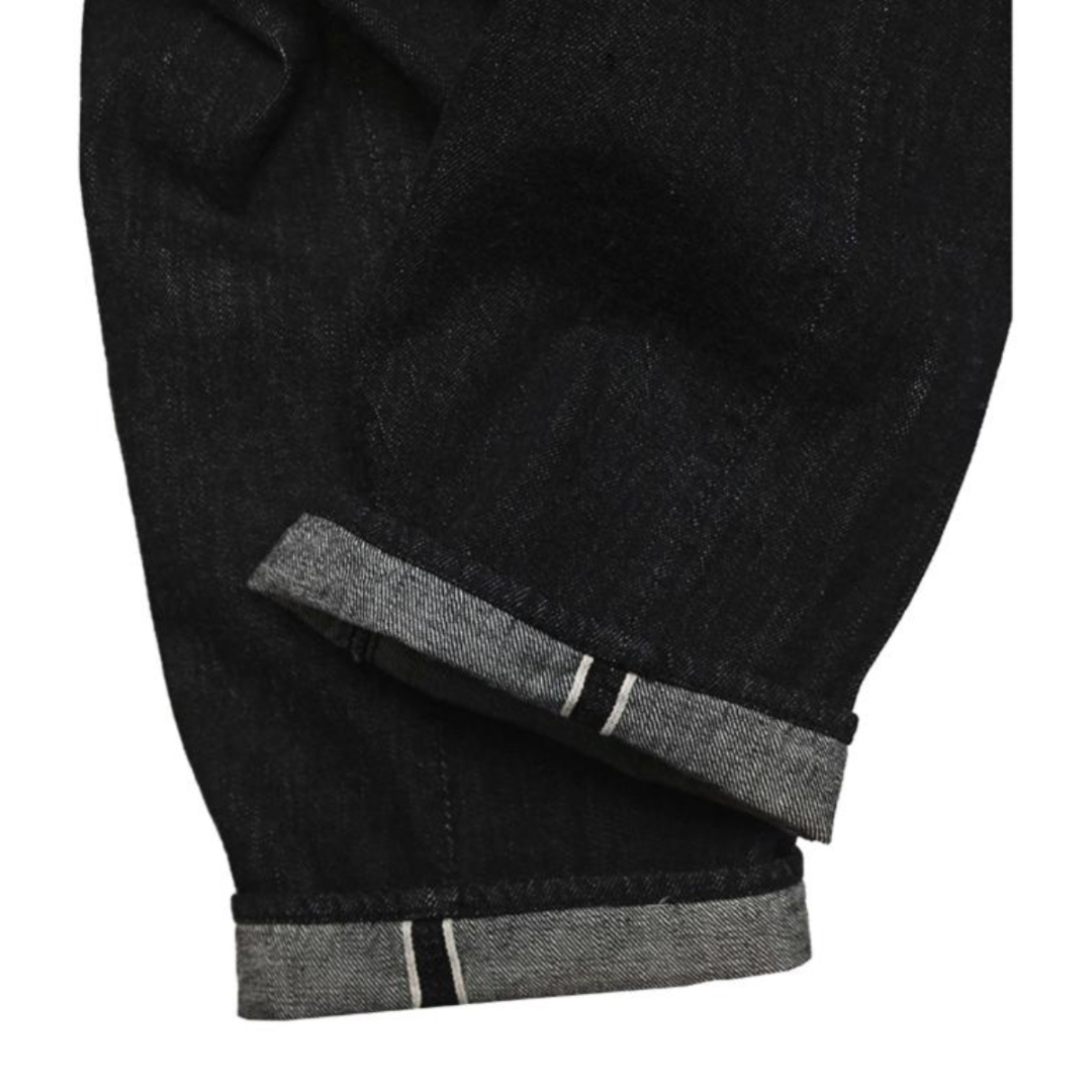 Close-up of black denim with gray cuffs on a white background
