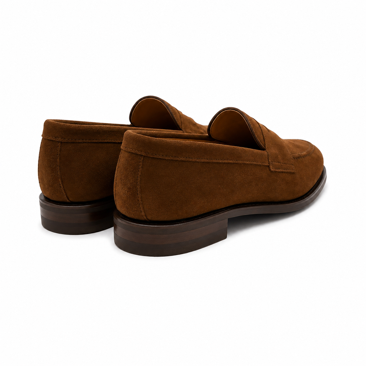 A pair of men's brown suede penny loafers shown from a rear three-quarter angle on a clean white background.