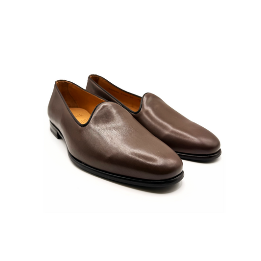 Pair of brown leather loafers on a white background