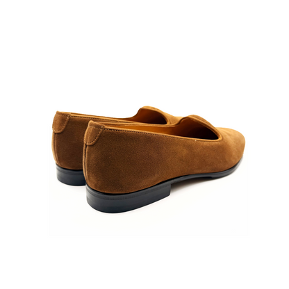 Pair of brown suede loafers on a white background