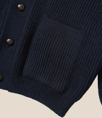 Navy blue cardigan with button details on a beige background