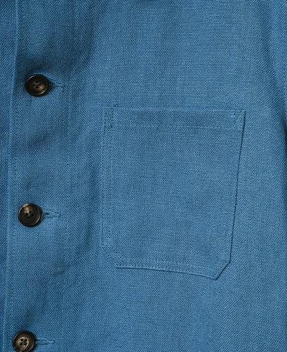 Close-up of a blue shirt with buttons and a pocket