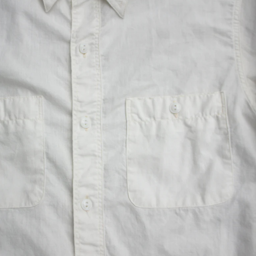 Close-up of a light gray button-up shirt with a pocket.