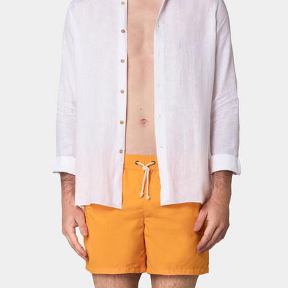 Person wearing a white shirt and orange shorts on a white background