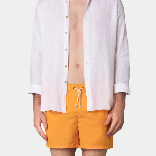 Person wearing a white shirt and orange shorts on a white background