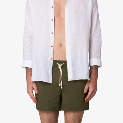 Person wearing a white shirt and green shorts on a white background