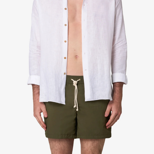 Person wearing a white shirt and green shorts on a white background