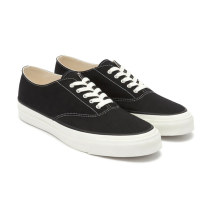 Pair of black sneakers with white laces on a white background