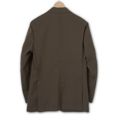 Kamakura brown seersucker jacket displayed on a hanger, showcasing lightweight, textured fabric and tailored fit.