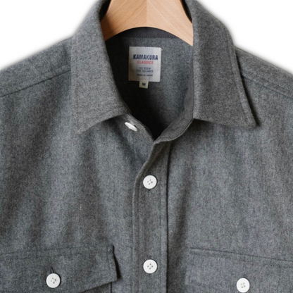 Kamakura grey wool flannel CPO shirt displayed on a hanger, showcasing its classic design and soft fabric details.