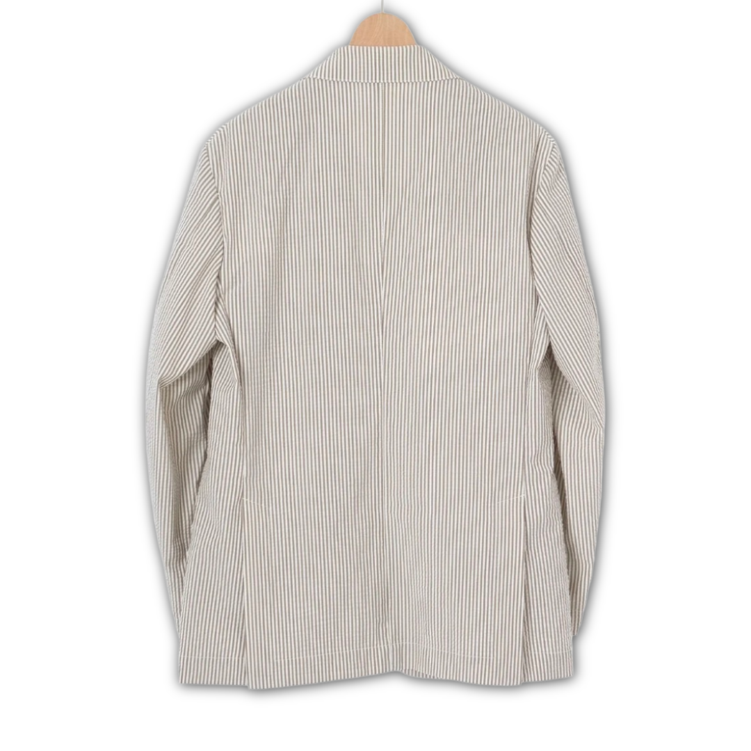 Kamakura beige seersucker jacket displayed on a hanger, showcasing its lightweight, textured fabric and classic collar design.
