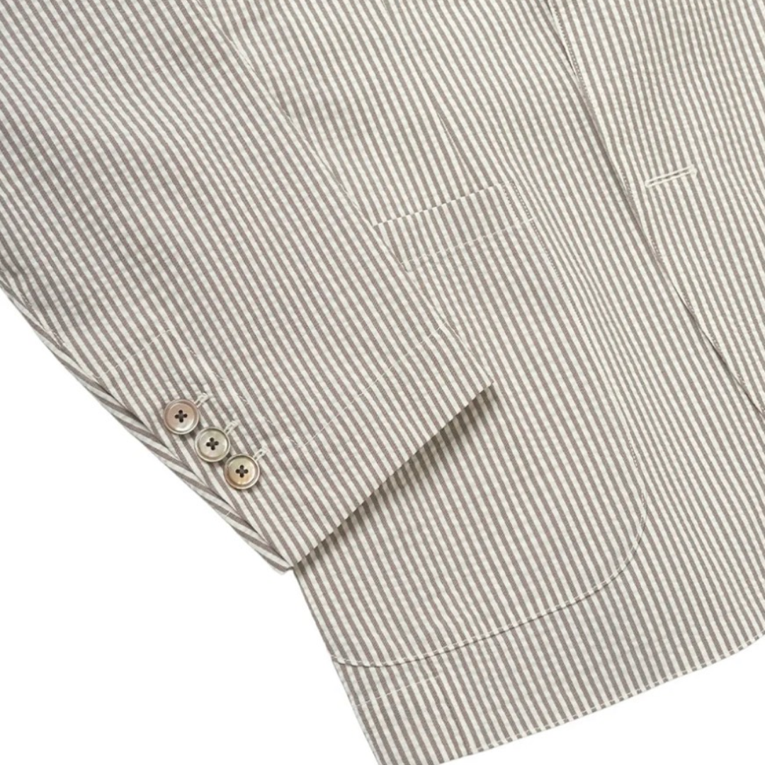 Beige Kamakura seersucker jacket shown on a hanger, featuring lightweight textured fabric and classic collar design.