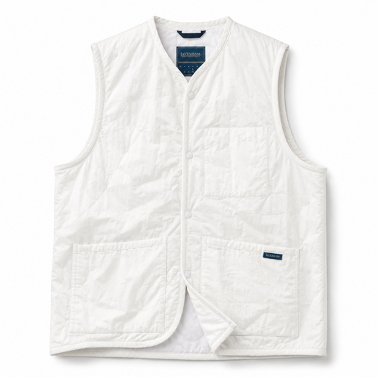 A white quilted sleeveless vest with a button front, two front patch pockets, and a visible Columbia label, photographed on a clean white background.