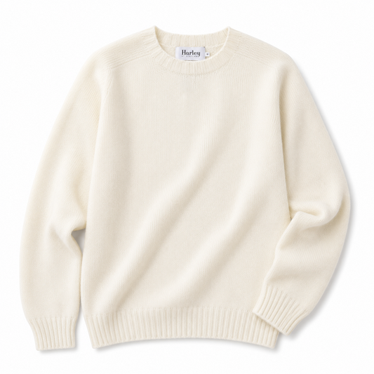 An off-white cream knit crewneck sweater with long sleeves and ribbed cuffs and hem, shown flat on a white background. The brand label inside the collar reads 'Harley'.