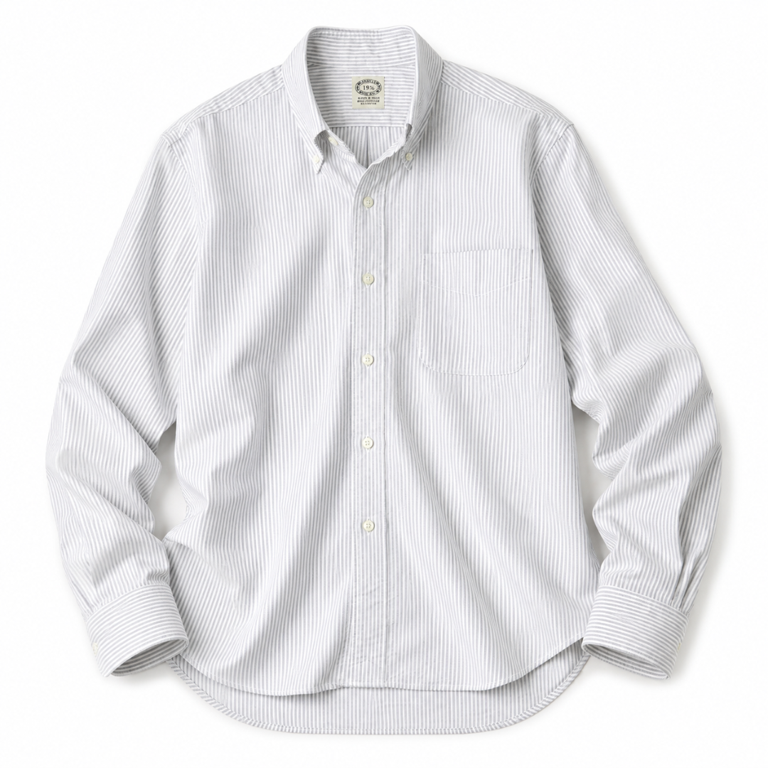 A white long-sleeve button-down shirt with thin vertical blue pinstripes, featuring a classic collar, button-up front, and a single chest pocket, laid flat against a white background.