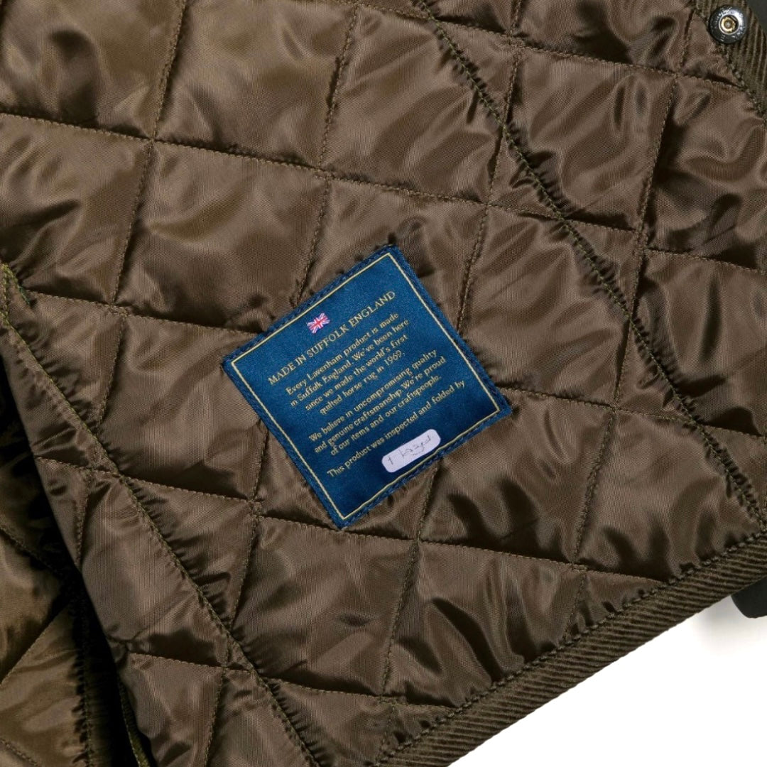Close-up of a quilted brown jacket with a brand label on a white background