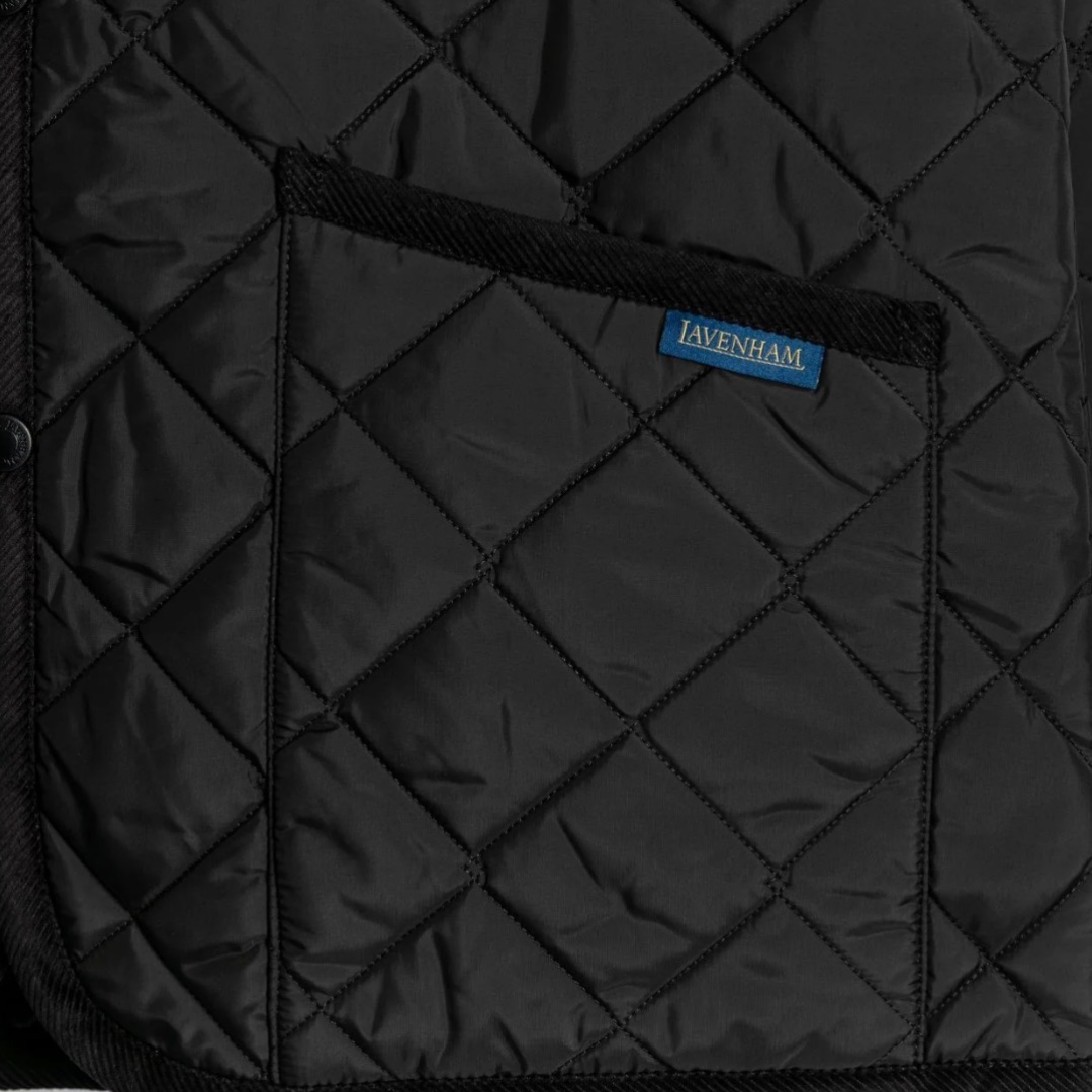 Black quilted saddle pad with a visible brand label on a black background