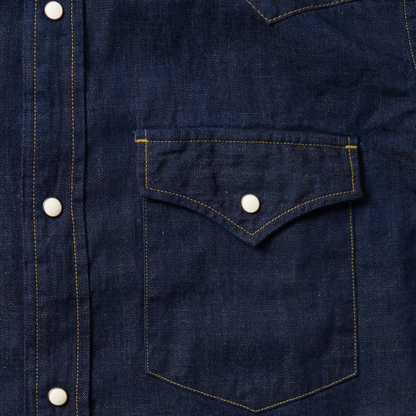 Close-up of a dark blue denim shirt with a pocket and buttons.